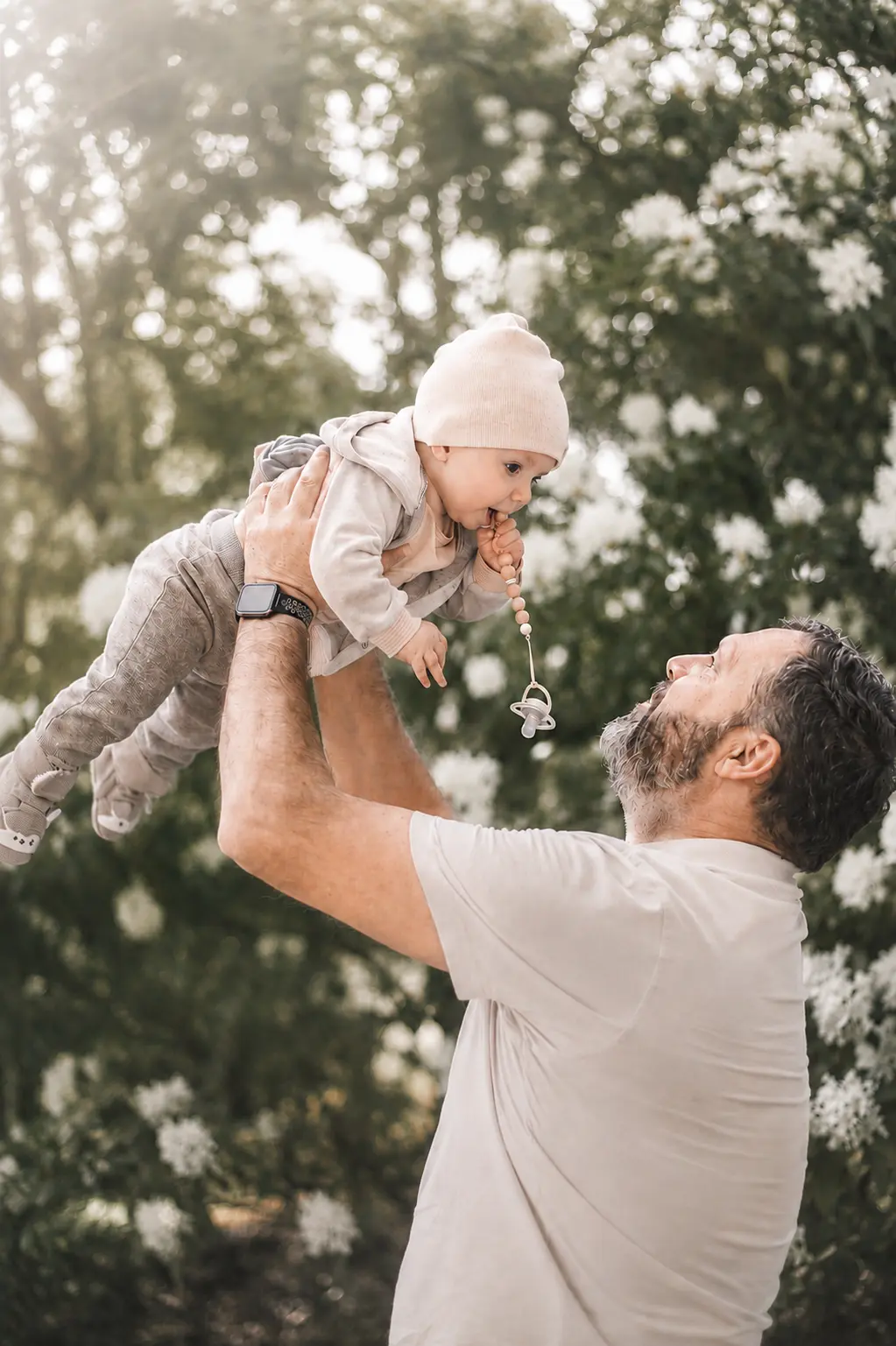 Vater hebt sein Baby draußen in die Luft